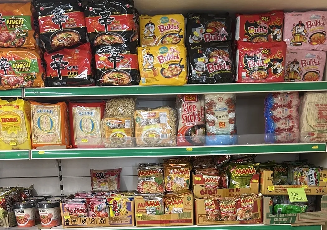 Shelves of Korean ramyun and Buldak noodles above rice sticks and vermicelli