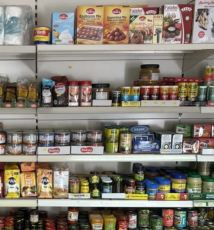 Shelves of Sofra basbousa, dumpling and falafel mixes above Bodrum jars, herbs and tins