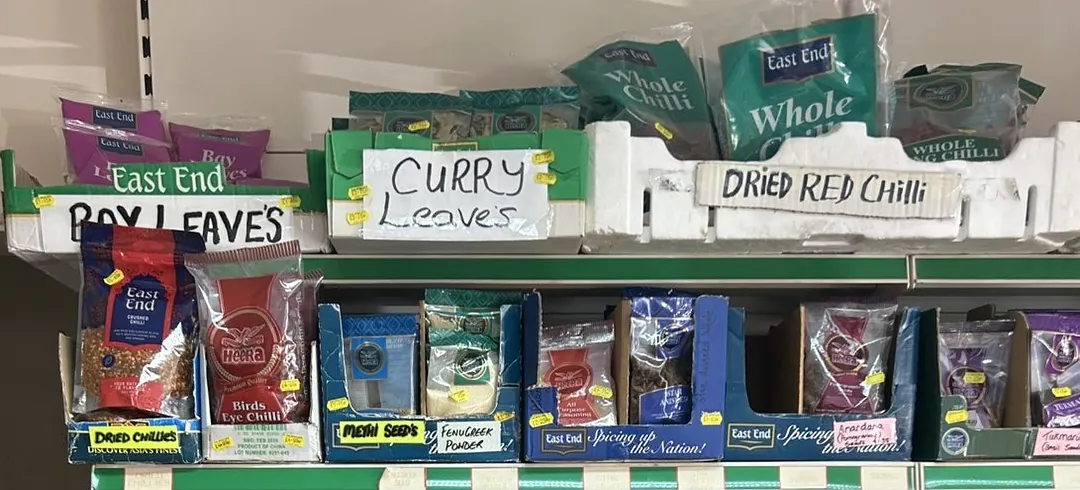 Bags of dried red chillies, curry leaves and dried herbs on the shelf